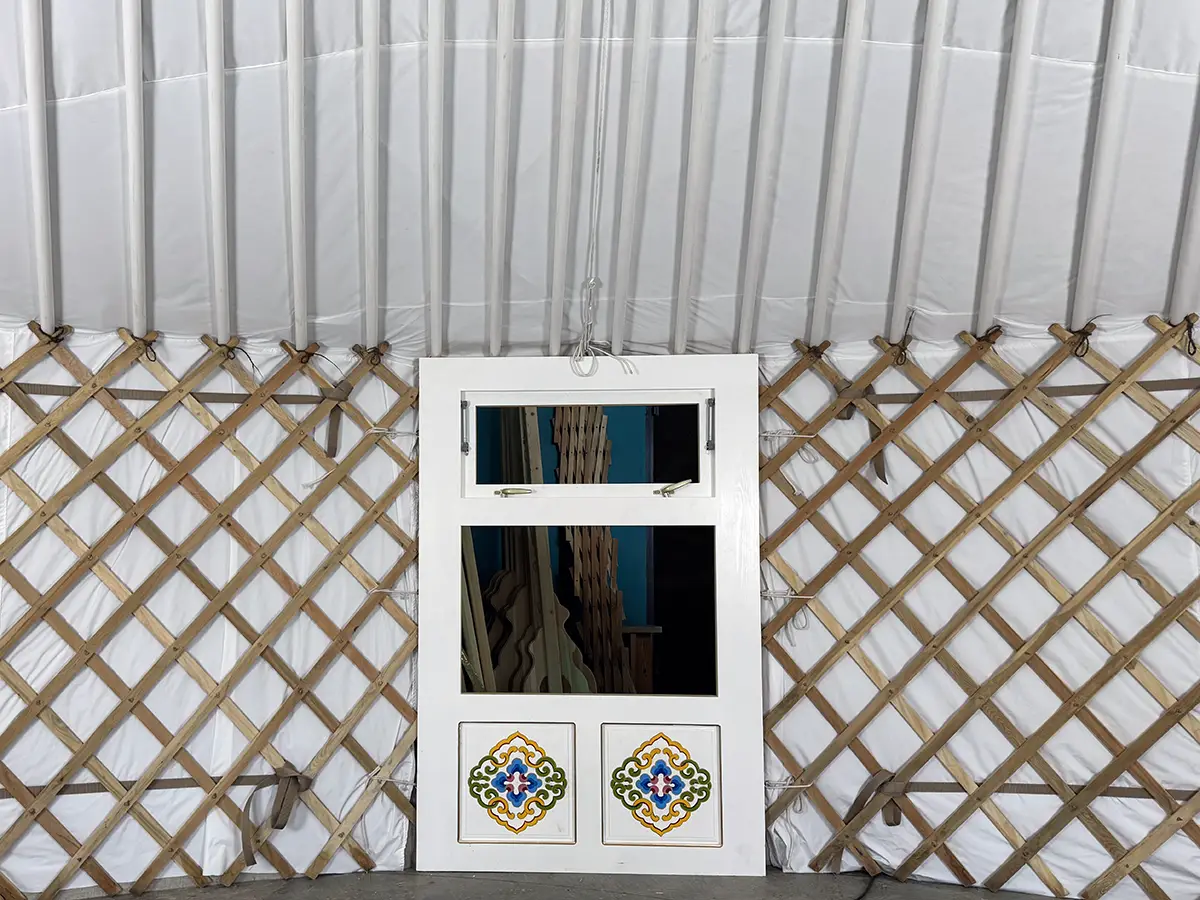 White interior of a Mongolian yurt showing a window with Mongolian traditional motif decoration