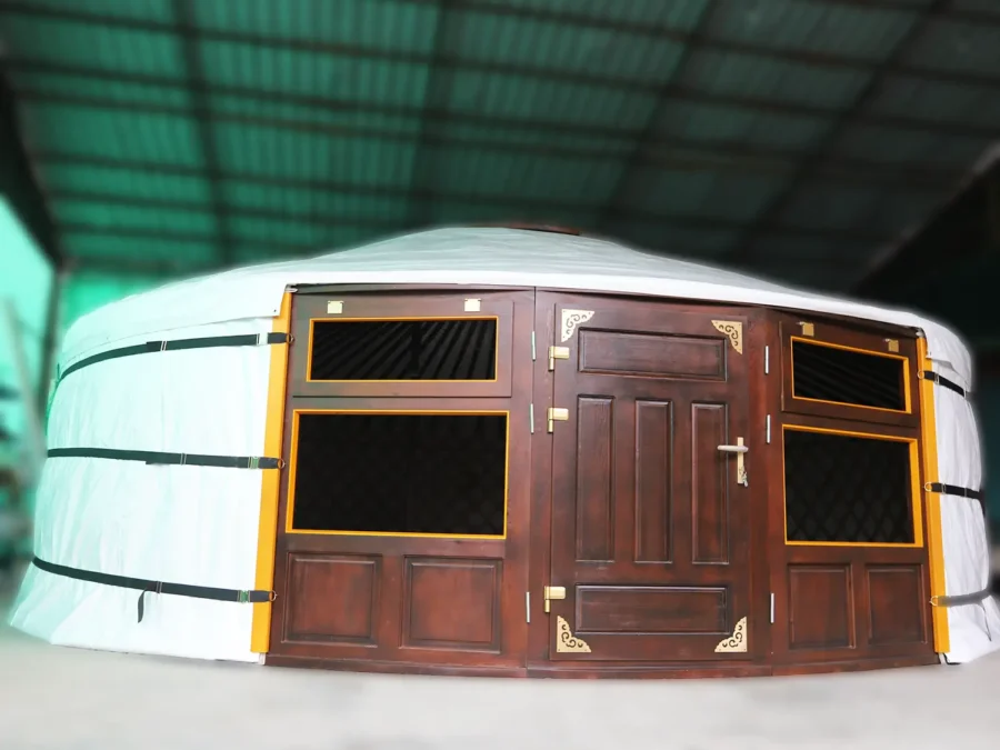 A Mongolian yurt with white cover and brown door