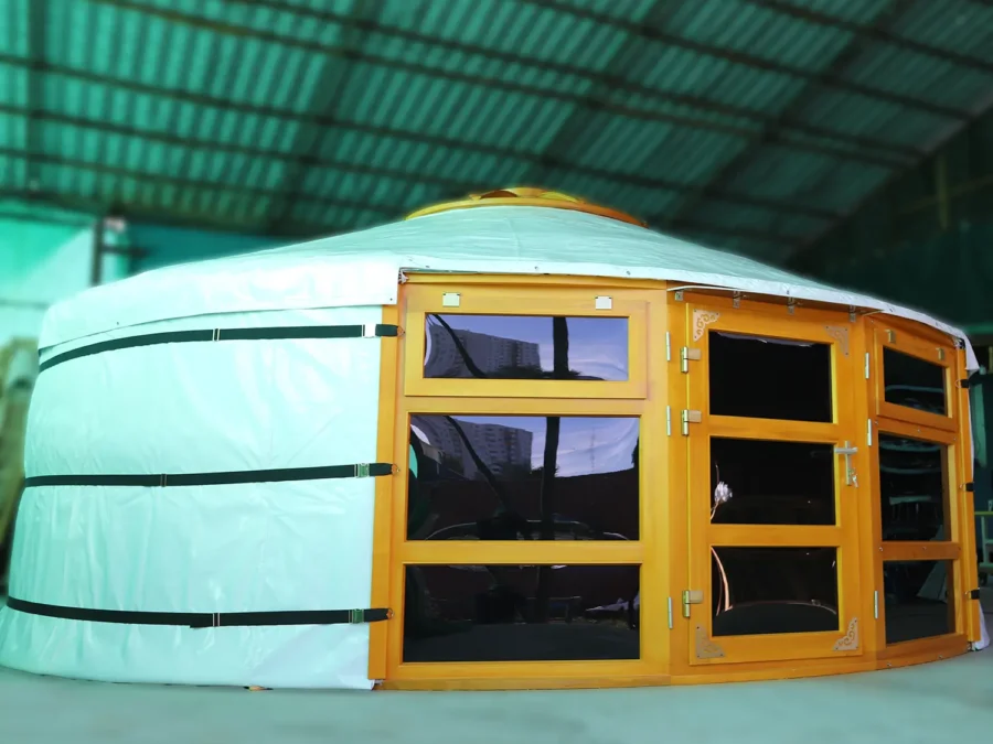 A Mongolian yurt with glass windows at two sides of the door, in white cover and yellow wood painting