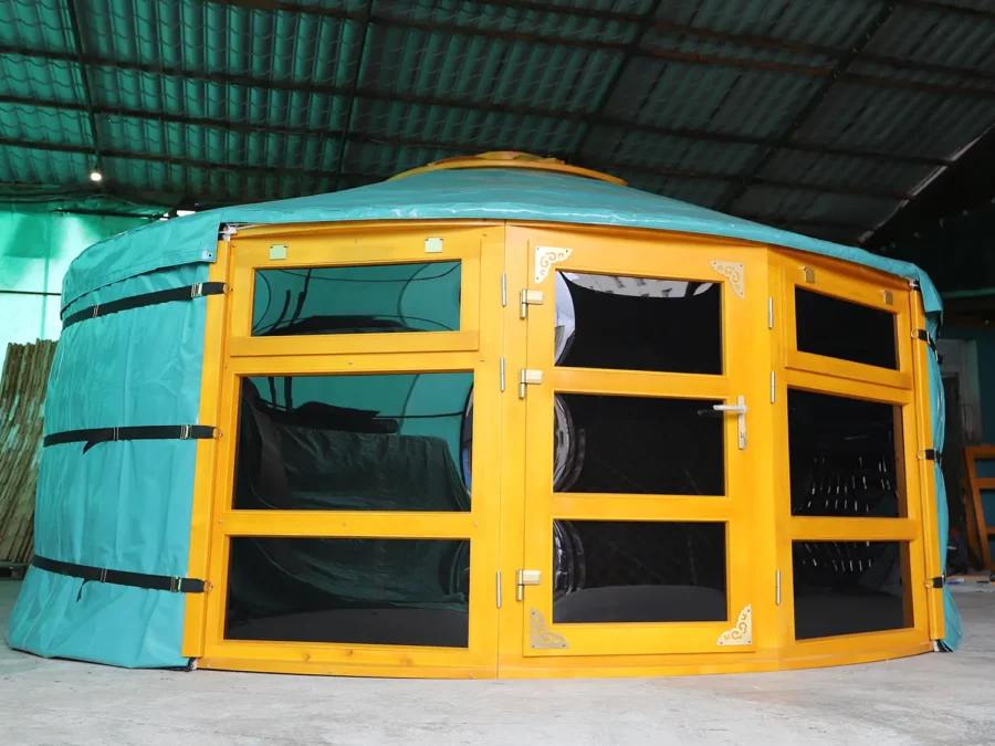 A Mongolian yurt with large glass windows painted in yellow color
