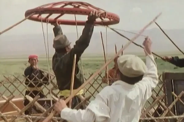 A man holding skylight of the yurt by hand